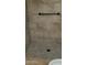 Tiled shower stall with tile flooring and bronze shower fixture and matching assist bar at 16758 W Apache St, Goodyear, AZ 85338