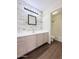 Bathroom with a rustic accent wall, laminate floor, and shower-tub combination at 1679 E Oakland St, Gilbert, AZ 85295