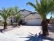 Attractive single-story home featuring a two-car garage and mature palm trees at 1679 E Oakland St, Gilbert, AZ 85295