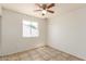 Bright bedroom featuring tile floors, a ceiling fan, and a window for natural light at 17244 N 36Th Ln, Glendale, AZ 85308