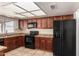 Updated kitchen featuring black appliances, wood cabinets, neutral countertop, and tile flooring at 17244 N 36Th Ln, Glendale, AZ 85308