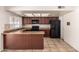 Kitchen featuring wood cabinets, black appliances, a breakfast bar, and natural light at 17244 N 36Th Ln, Glendale, AZ 85308