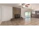 Living room with tile flooring, brick fireplace, ceiling fan, and sliding door to the patio at 17244 N 36Th Ln, Glendale, AZ 85308