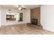 Spacious living area showcasing a brick fireplace, tile flooring, ceiling fan and kitchen view at 17244 N 36Th Ln, Glendale, AZ 85308