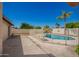 Backyard featuring a fenced pool, complemented by mature trees and an open patio space at 17244 N 36Th Ln, Glendale, AZ 85308