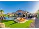 Serene backyard featuring a sparkling pool, comfortable lounge chairs, and a covered patio with built-in grill at 1753 N Berrett --, Mesa, AZ 85207