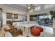Open-concept living room features stylish furniture, island seating, and a sliding glass door to the outdoor space at 1753 N Berrett --, Mesa, AZ 85207