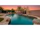 Beautiful pool features a rock waterfall, decorative metal panels, and lush landscaping for a serene backyard at 1753 N Berrett --, Mesa, AZ 85207