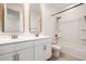 Bright bathroom featuring double vanity sinks, modern fixtures, and a bathtub with a shower at 17864 W Fetlock Trl, Surprise, AZ 85387