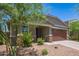 Attractive single-story home with stone accents, a two-car garage, and mature desert landscaping at 17864 W Fetlock Trl, Surprise, AZ 85387