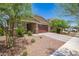 Charming single-story home featuring a stone-accented facade, two-car garage, and desert landscaping at 17864 W Fetlock Trl, Surprise, AZ 85387
