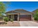 Inviting one-story home with a two-car garage, desert landscaping, and a covered porch at 17864 W Fetlock Trl, Surprise, AZ 85387