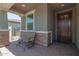 Cozy front porch with stone pillars, a seating area, and a view of the surrounding neighborhood at 17864 W Fetlock Trl, Surprise, AZ 85387