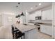 Open-concept kitchen with granite counters, island seating, and stainless steel appliances at 17864 W Fetlock Trl, Surprise, AZ 85387
