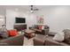 Comfortable living room featuring leather furniture, a ceiling fan, and a large flat-screen TV at 17864 W Fetlock Trl, Surprise, AZ 85387