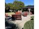 Landscaped backyard with a hot tub, pergola, seating area, and vibrant citrus trees at 18132 E Vencino St, Gilbert, AZ 85298