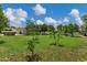Large backyard with lush greenery, young trees planted, and a metal building in the distance, perfect for outdoor activities at 18132 E Vencino St, Gilbert, AZ 85298