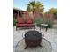 Inviting backyard patio featuring a fire pit, bench seating, lush plants and pavers at 18132 E Vencino St, Gilbert, AZ 85298