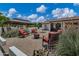 Backyard patio featuring a gazebo, fire pit, outdoor seating, lush landscaping and exterior home view at 18132 E Vencino St, Gilbert, AZ 85298