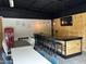 Interior of a bar area with wooden accents, bar seating and refrigerator at 18132 E Vencino St, Gilbert, AZ 85298