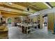 Spacious basement workshop with ample lighting, work tables, tool storage, and a convenient roll-up door at 18132 E Vencino St, Gilbert, AZ 85298