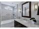 Stylish bathroom with a tub-shower, modern vanity, and elegant lighting fixtures at 18132 E Vencino St, Gilbert, AZ 85298