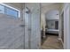 Well-lit bathroom with a glass-enclosed shower, tile surround, and view into the main bedroom at 18132 E Vencino St, Gilbert, AZ 85298