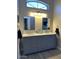 Bathroom with a double vanity with marble countertop and dual sinks beneath a large window at 18132 E Vencino St, Gilbert, AZ 85298