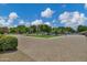 Long paved driveway leading to a property with lush landscaping and mature trees at 18132 E Vencino St, Gilbert, AZ 85298