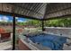 Hot tub under gazebo: luxurious backyard oasis with a rejuvenating hot tub for relaxation and enjoyment at 18132 E Vencino St, Gilbert, AZ 85298