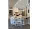 A kitchen with a quartz countertop, an island with two chairs, and stainless steel appliances at 18132 E Vencino St, Gilbert, AZ 85298