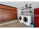 Laundry room featuring cabinets, front load washer & dryer, and industrial shelving at 18132 E Vencino St, Gilbert, AZ 85298