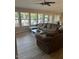A living room with a brown couch, a coffee table, and a wall of windows overlooking the backyard at 18132 E Vencino St, Gilbert, AZ 85298