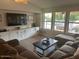 A living room with a brown couch, a coffee table, a wall of windows and custom built in cabinets at 18132 E Vencino St, Gilbert, AZ 85298