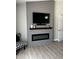 Modern living room features a mounted TV, faux fireplace, shiplap wall, and tile floors at 18132 E Vencino St, Gilbert, AZ 85298
