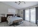 Spacious main bedroom featuring a ceiling fan, wood floors, and sliding glass doors leading to the backyard at 18132 E Vencino St, Gilbert, AZ 85298