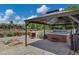 Covered patio with pavers, outdoor hot tub, seating, and desert landscaping at 18132 E Vencino St, Gilbert, AZ 85298