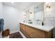 Bathroom featuring a double vanity with white countertop, wood cabinets, and tiled walls at 1831 W Seldon Ln, Phoenix, AZ 85021