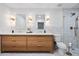 Bright bathroom featuring double vanity with white countertop, wood cabinets, and tiled walls at 1831 W Seldon Ln, Phoenix, AZ 85021