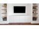 Built-in shelves with storage, natural wood shelves, and a sleek design in this living area at 1831 W Seldon Ln, Phoenix, AZ 85021