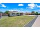 Single-story house with a well-maintained green lawn and classic brick exterior, set under a clear, blue sky at 1831 W Seldon Ln, Phoenix, AZ 85021