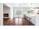 Bright kitchen with white cabinets, long island with seating, and view to a cozy living room with fireplace at 1831 W Seldon Ln, Phoenix, AZ 85021