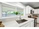 Kitchen featuring stainless sink, quartz countertops, shaker cabinets and a garden view through the window at 1831 W Seldon Ln, Phoenix, AZ 85021