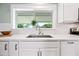 Kitchen featuring an apron-front sink, quartz countertop, herringbone tile backsplash, and ample natural light at 1831 W Seldon Ln, Phoenix, AZ 85021