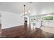 Open-concept living room with dark hardwood floors, stylish lighting, and a glimpse into the kitchen at 1831 W Seldon Ln, Phoenix, AZ 85021