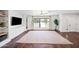 Bright living room with wood floors, ceiling fan, large front window, and built-in storage and display shelves at 1831 W Seldon Ln, Phoenix, AZ 85021