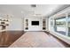 Living room with hardwood floors, built-in shelves, TV, and large windows overlooking the outdoor landscape at 1831 W Seldon Ln, Phoenix, AZ 85021
