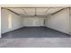 Spacious garage featuring an epoxy floor, white brick walls, and three access doors at 19 E Boca Raton Rd, Phoenix, AZ 85022
