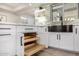 White kitchen cabinets feature pull-out shelves and matte black hardware; stylish and efficient storage solutions at 19 E Boca Raton Rd, Phoenix, AZ 85022