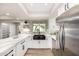 Well-lit kitchen featuring stainless steel appliances, a matte black sink, and bright white cabinets at 19 E Boca Raton Rd, Phoenix, AZ 85022